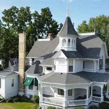 A large white house with many windows and a porch.