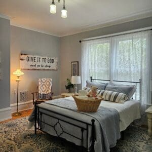 A bedroom with a bed, chair and window.