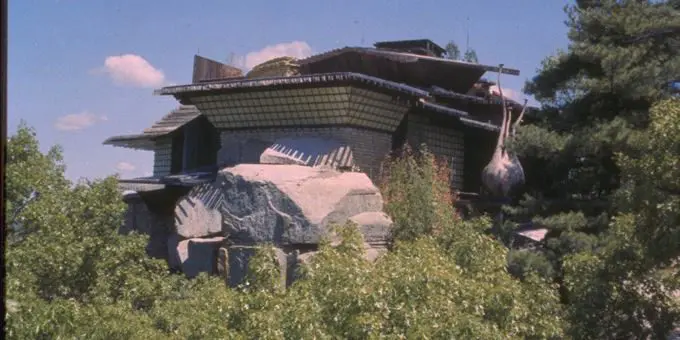 A building with a large rock in front of it.