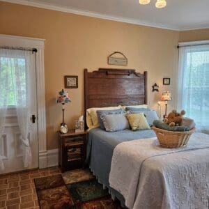 A bedroom with a bed, nightstand and dresser.