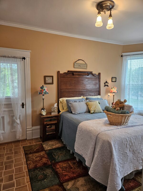 A bedroom with a bed, nightstand and dresser.