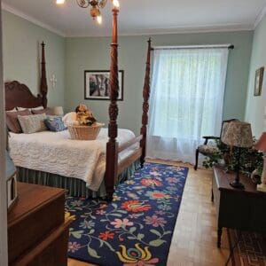 A bedroom with a bed, dresser and chair.