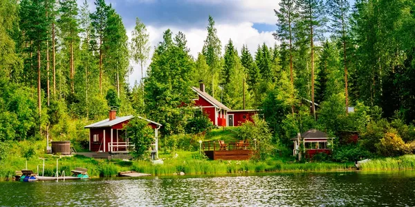 A lake with some houses and trees in the background