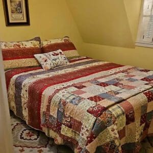 A bed with a quilt on it in a room.