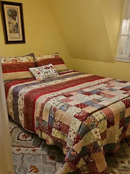 A bed with a quilt on it in a room.